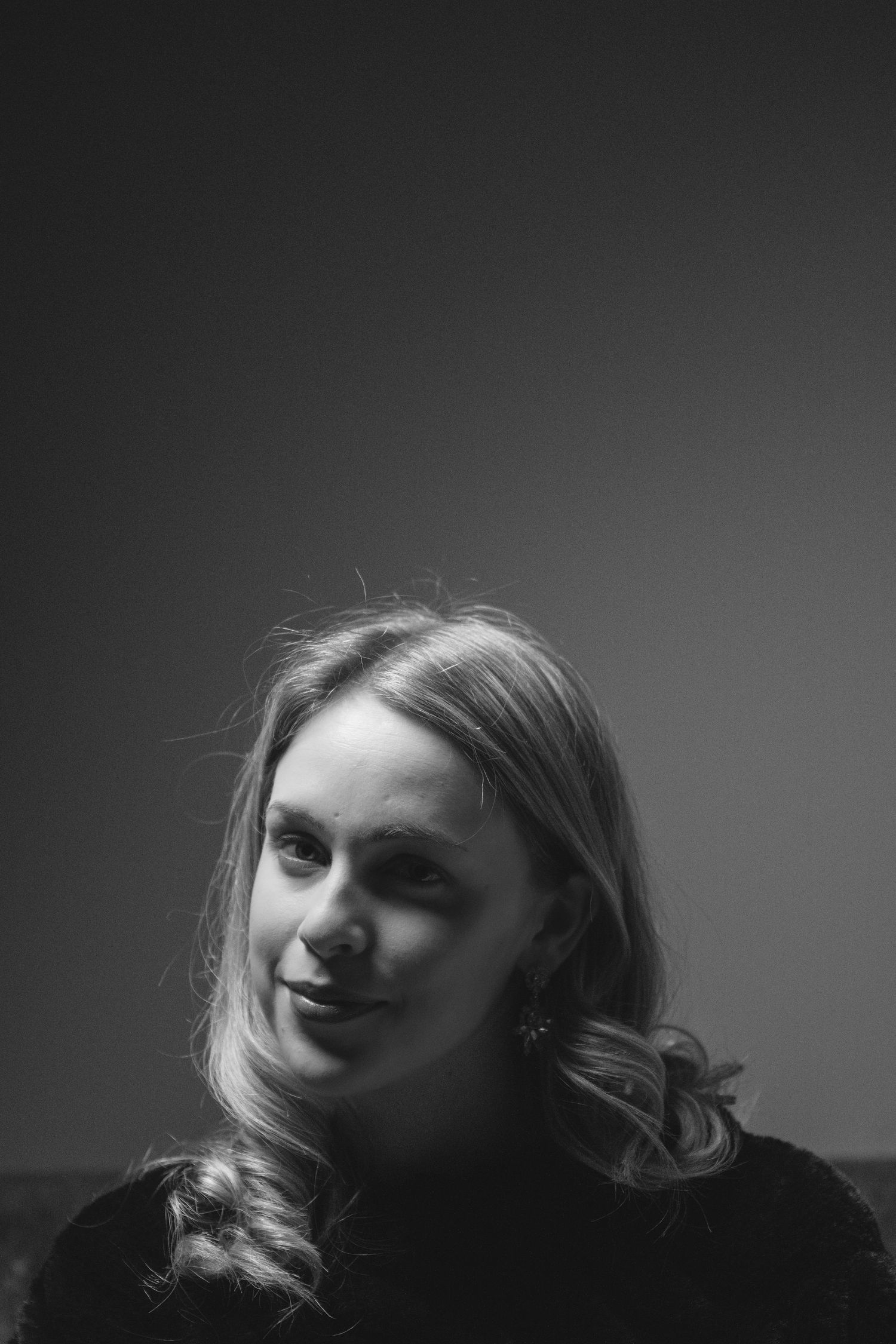 Dramatic black and white portrait series showing different angles of a person's face in moody lighting.