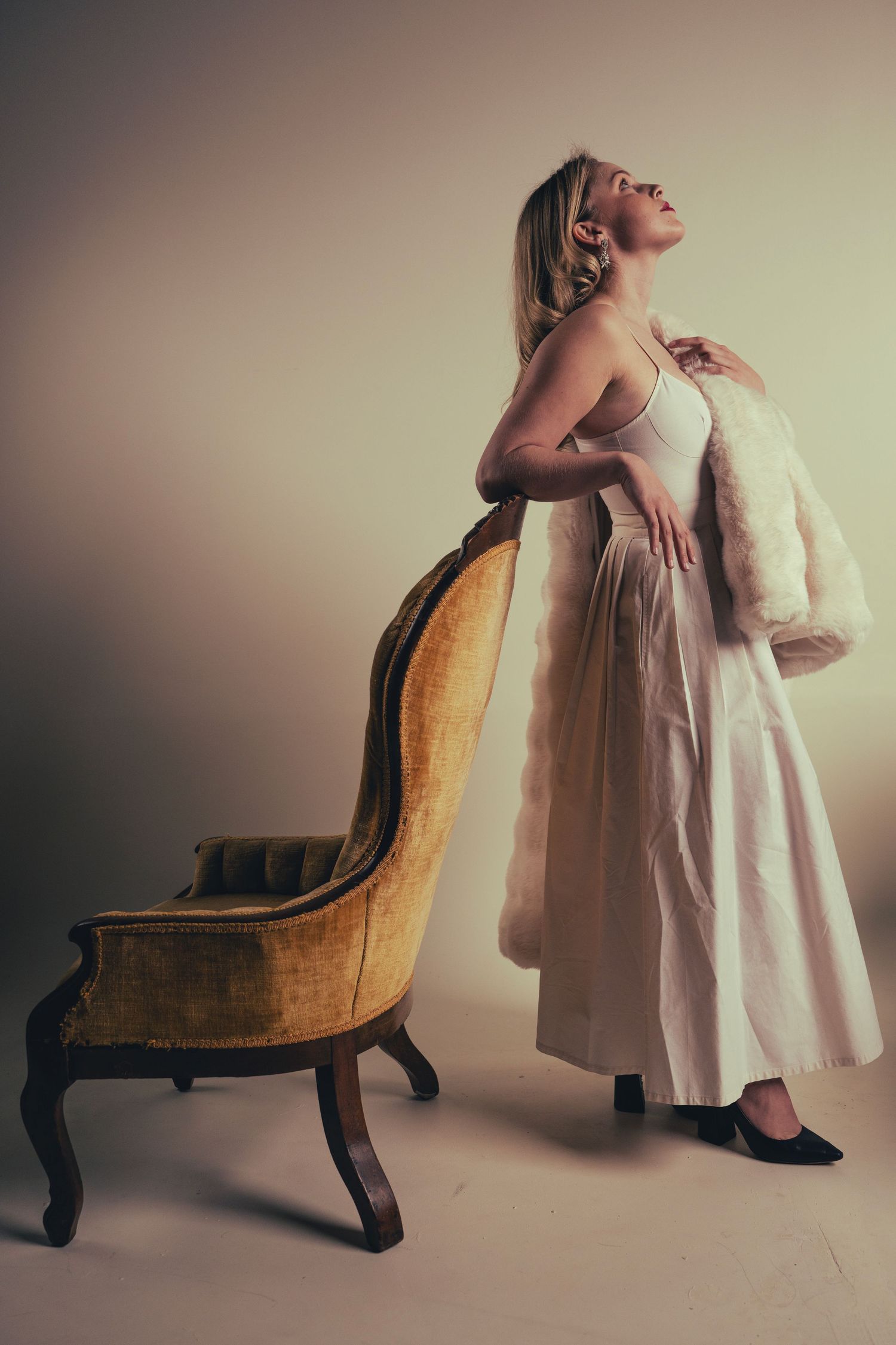 Sequential art showing graceful movement around an antique chair in a white dress.