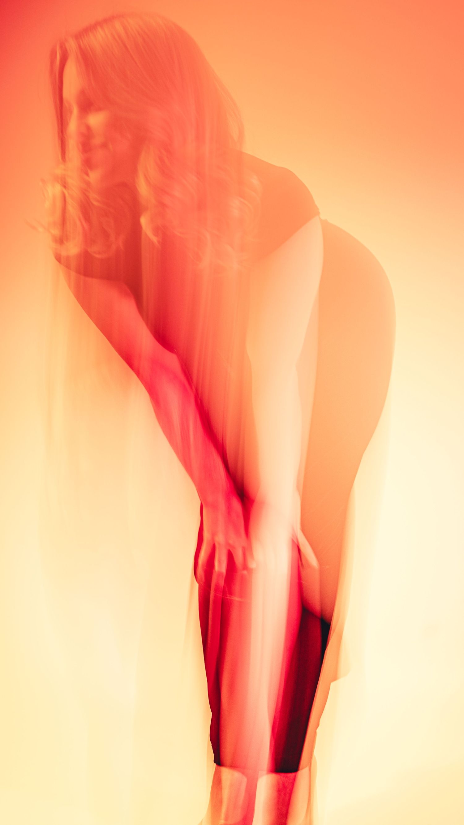 Abstract motion blur sequence in orange and red tones creating ethereal movement patterns.