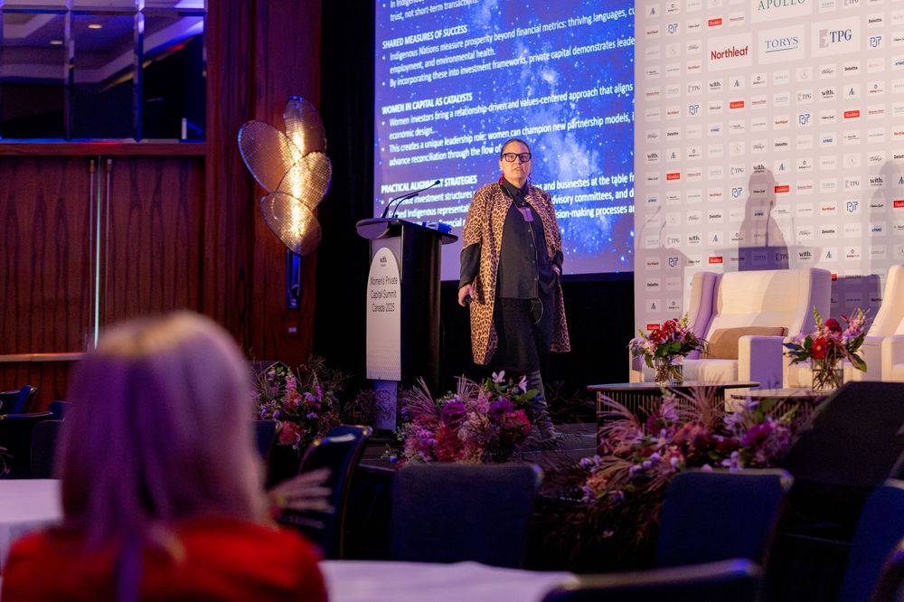 Conference stage setup with blue circular branding and professional lighting at business summit.