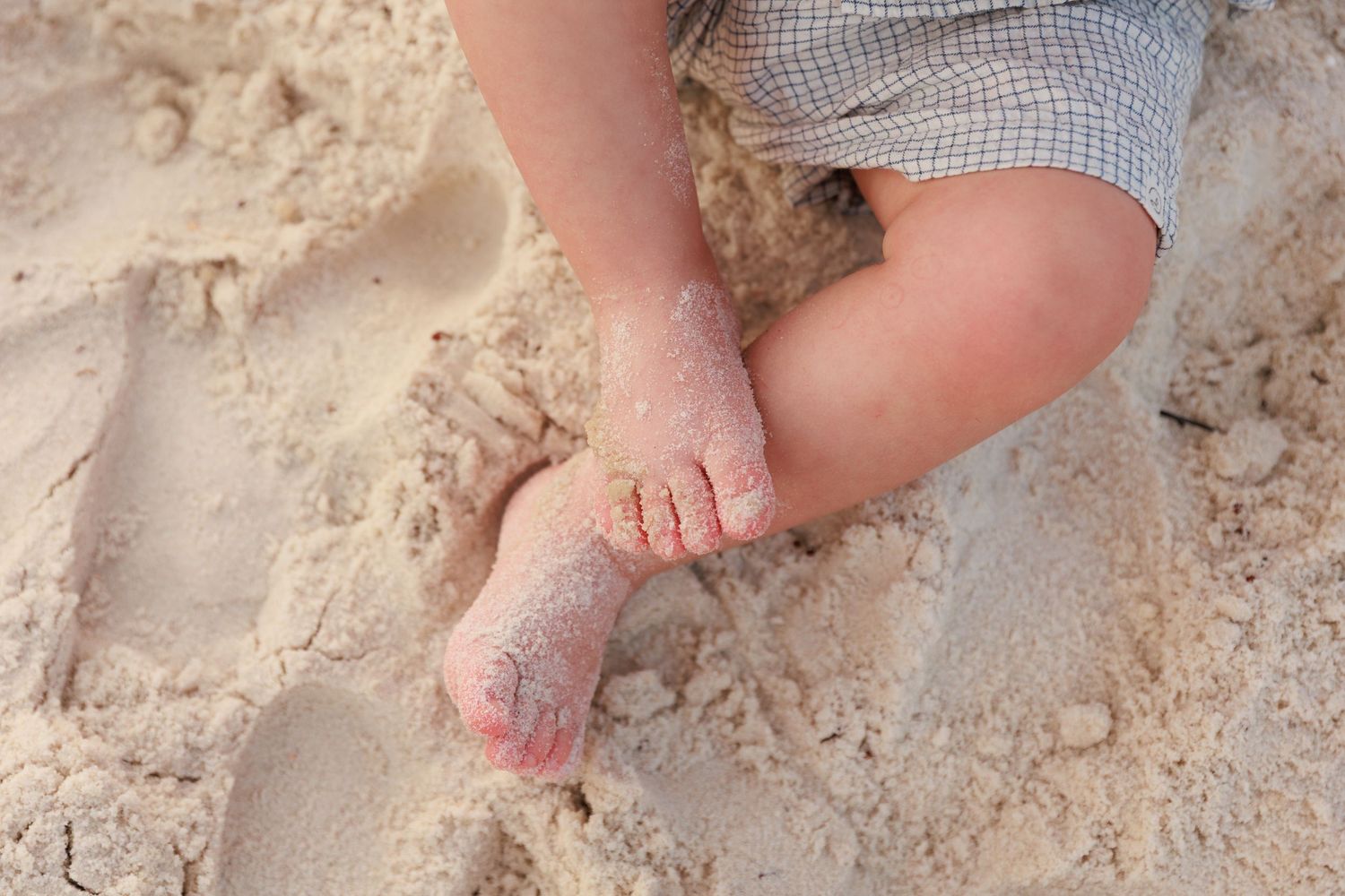 Close up of feet standing on foot placement markers on grey ground.