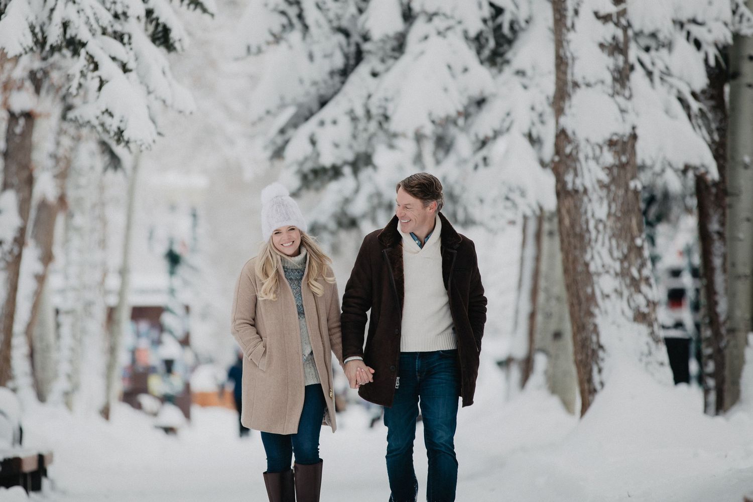 A romantic moment captured on a path through a serene aspen forest with white tree trunks and green foliage.