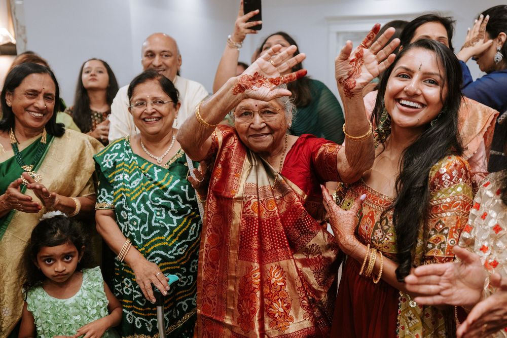 A joyful group in colorful traditional Indian attire dancing and celebrating at a cultural gathering.