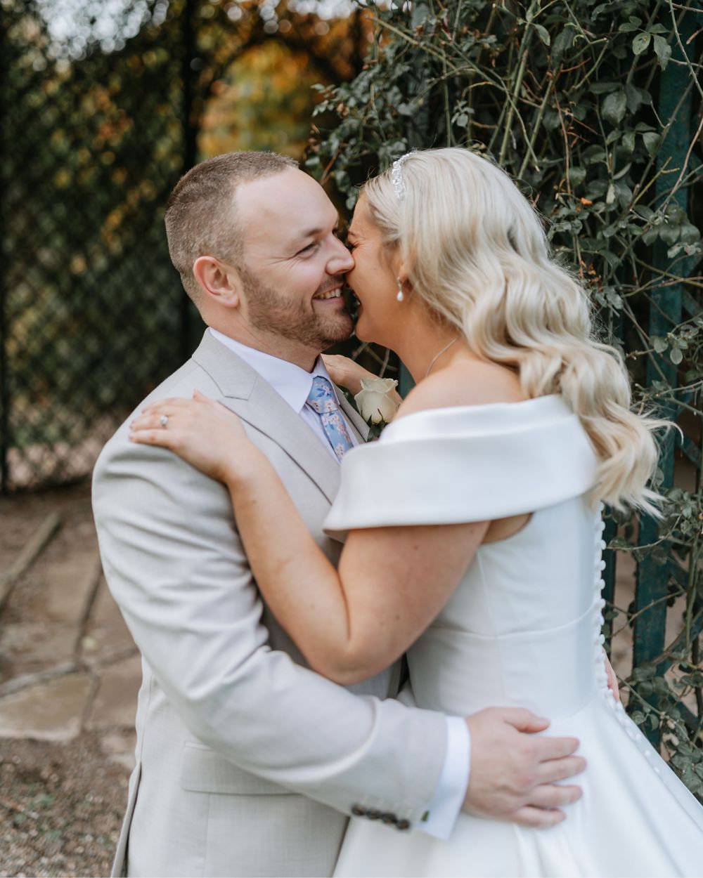 A romantic wedding moment captured in a garden setting with soft natural lighting.
