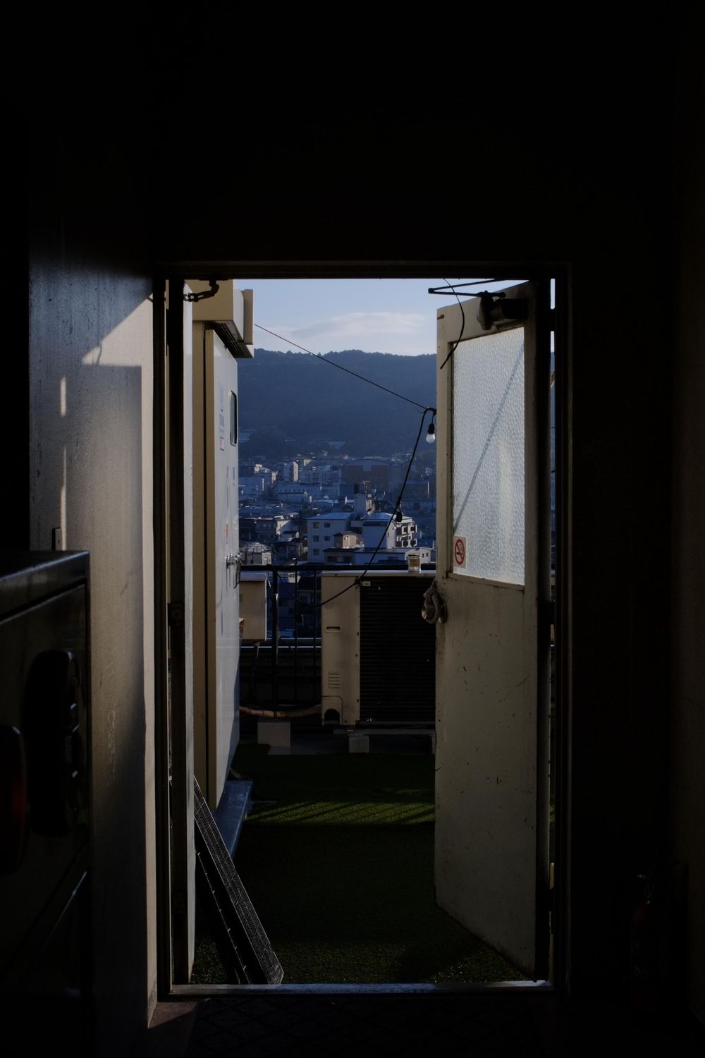 A series of dark doorway views showing a cityscape and mountains in the distance through interior frames.