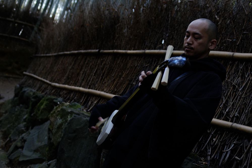 Traditional bamboo fence in a dimly lit Japanese garden setting.