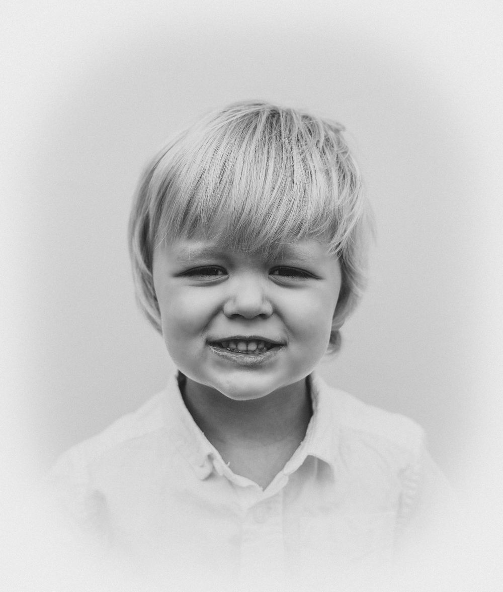 A series of black and white portrait shots showing expressions of joy and laughter against a light background.