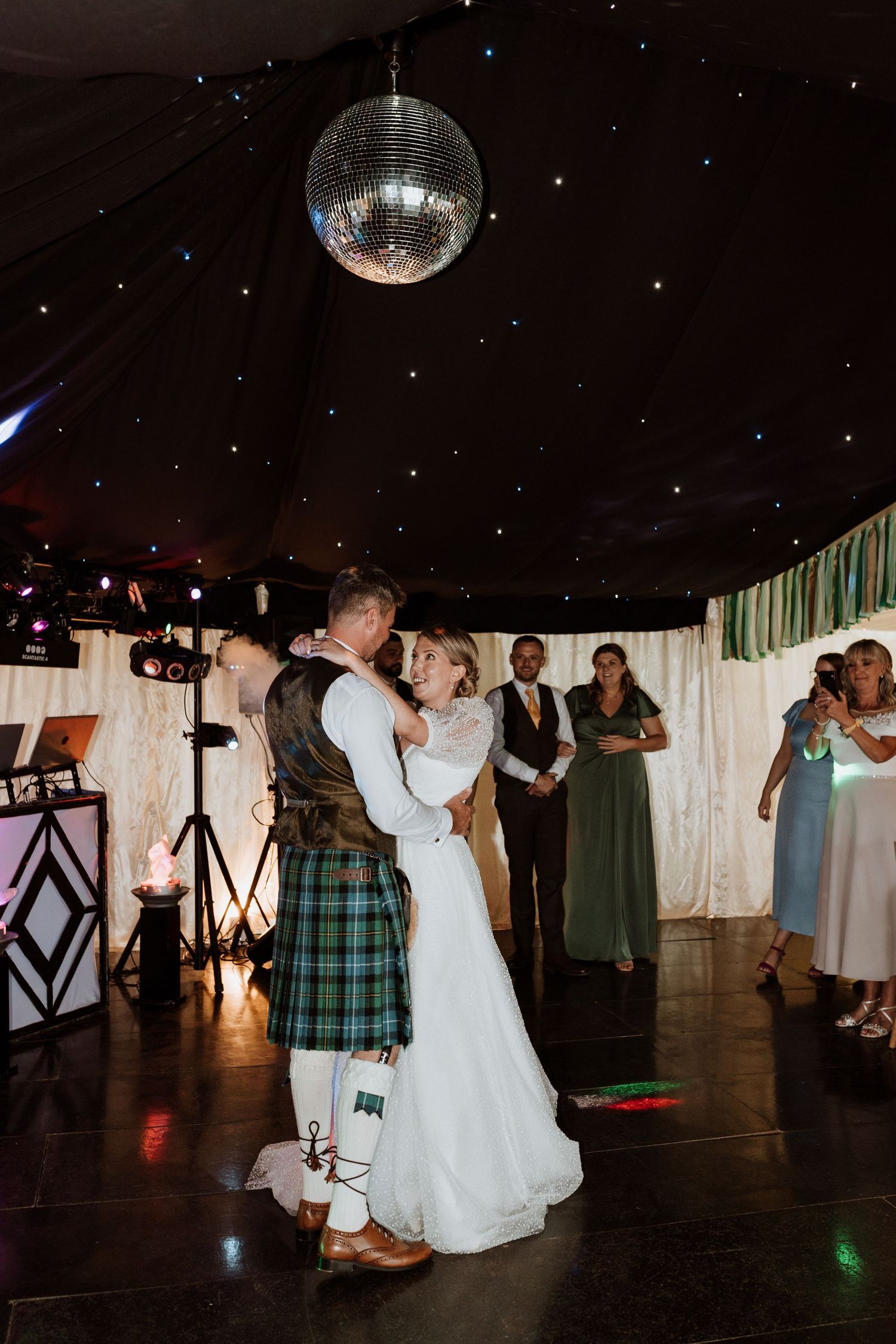 A wedding reception dance floor sequence shows the couple and guests dancing under a disco ball and party lights.