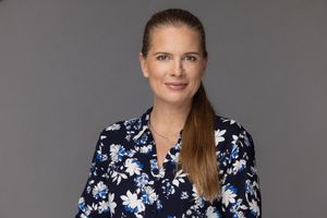 A figure wearing a navy blue and white floral dress poses across four sequential headshots.