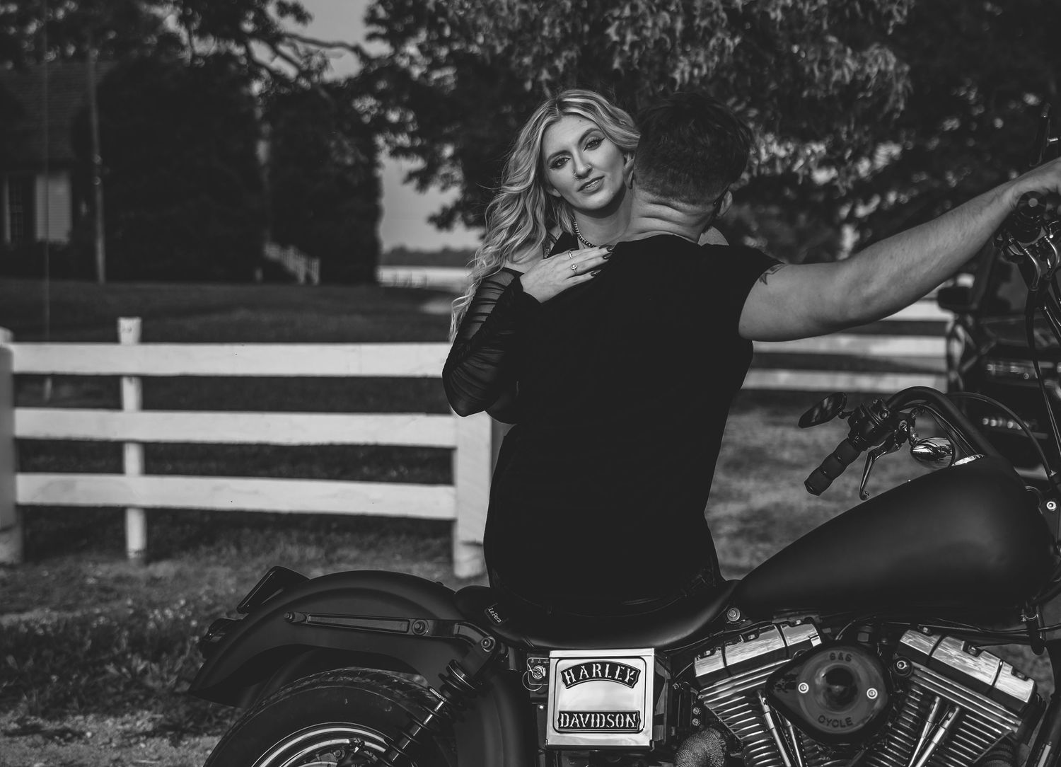 A motorcycle photoshoot featuring a custom bike against a rural backdrop with white fencing.