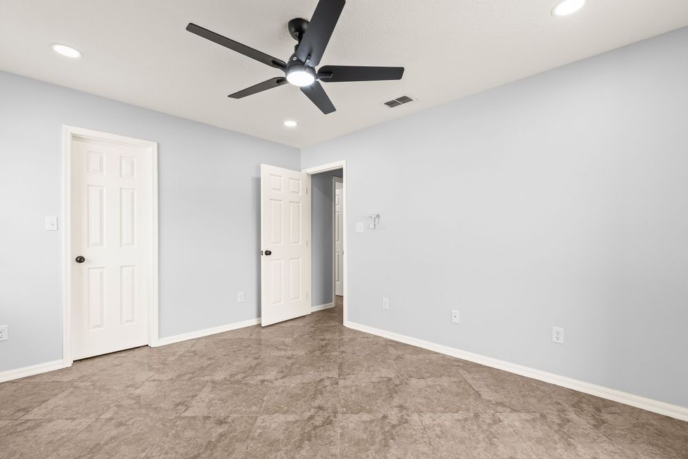 Fresh painted gray room with white doors, ceiling fan, and modern lighting fixtures.