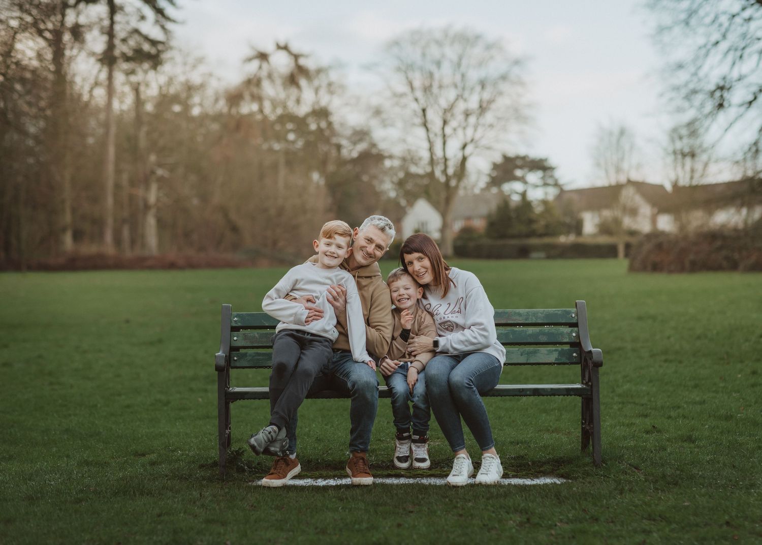 A series of family portraits showing joyful moments while sitting together on a park bench at sunset.