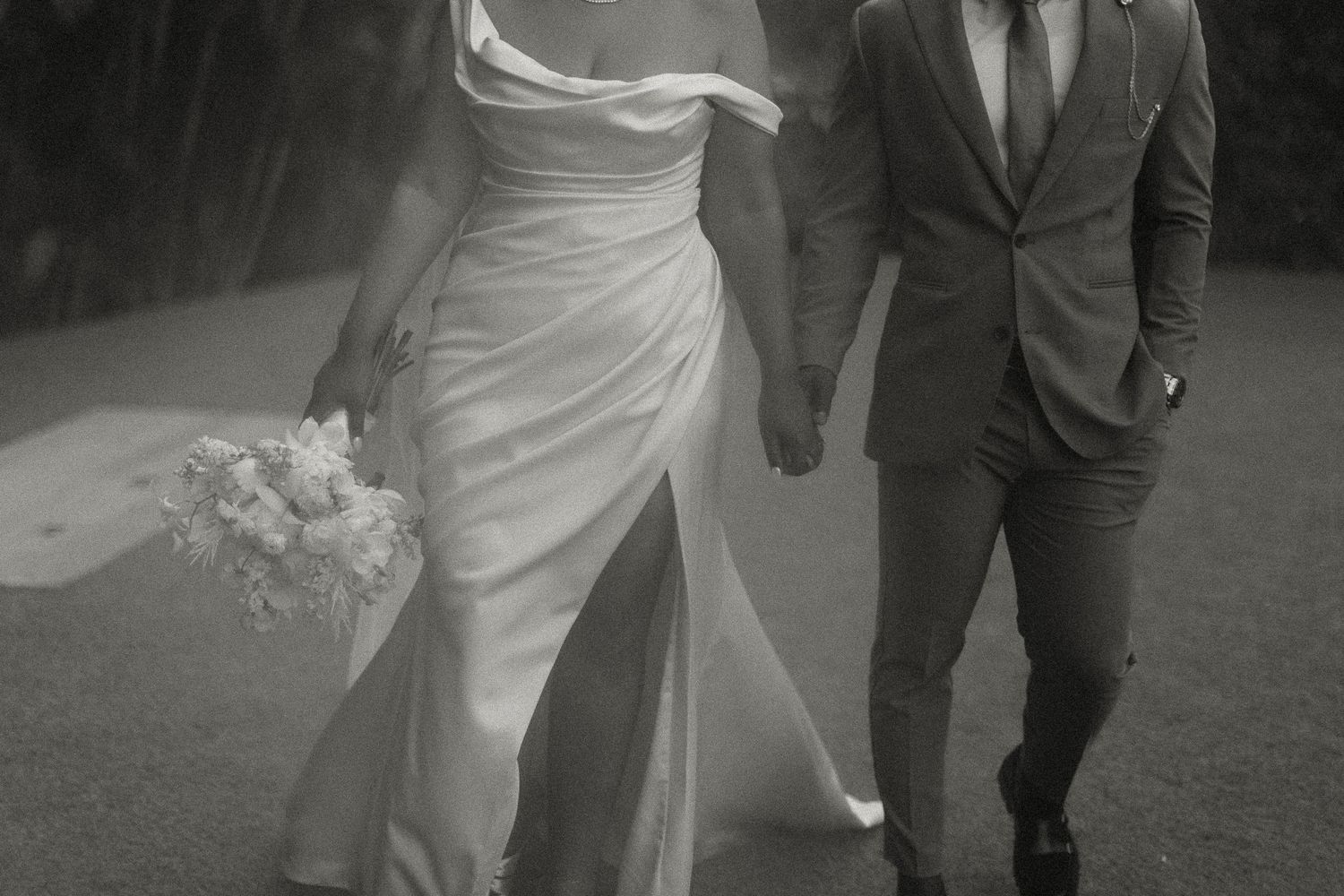 Black and white photo of a bride and groom walking hand in hand in the rain on their wedding day. Mexico City Miranda Photo & Co