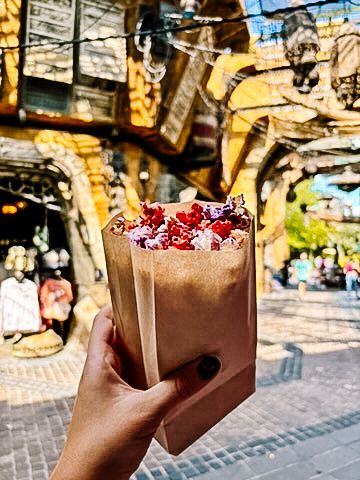 Chocolate beverage topped with red berries served in a paper cup at Galaxy's Edge.