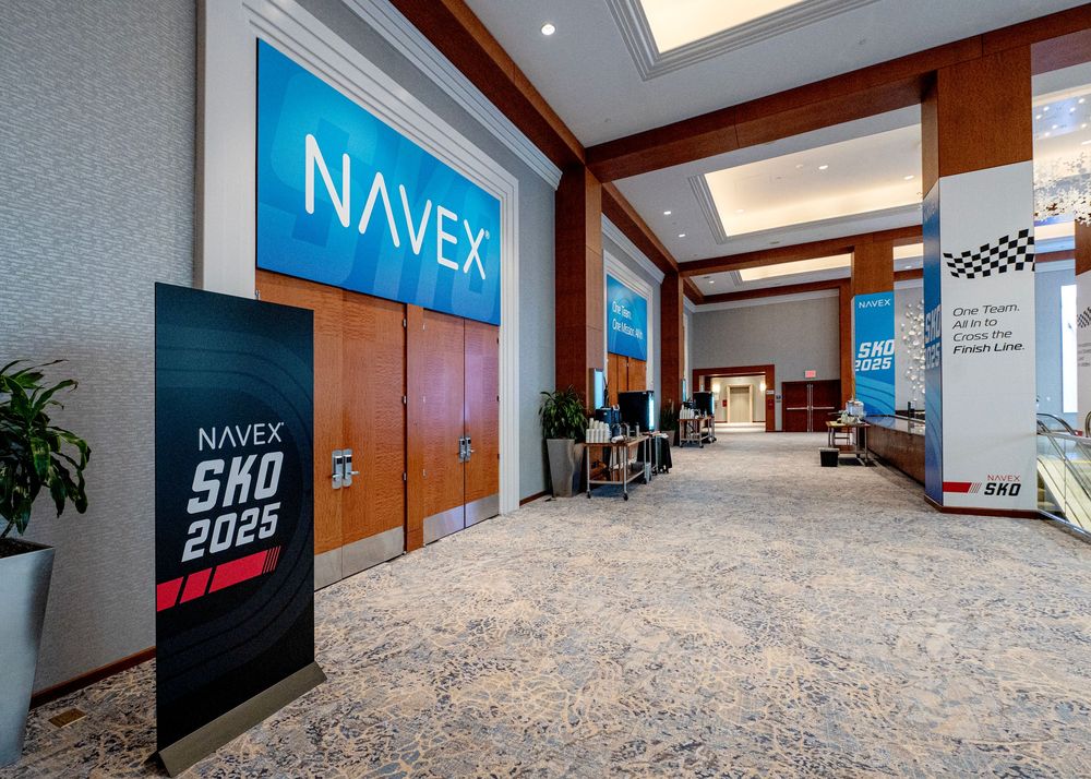 Corporate office hallway featuring NAVEX branding and racing-themed wall displays.