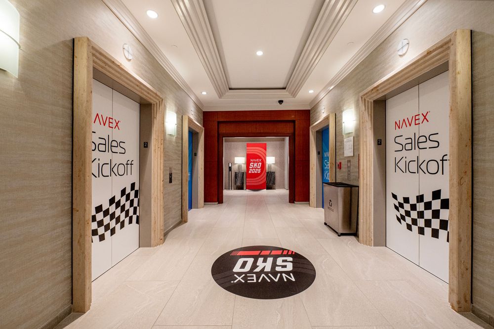 Corporate hallway with racing-themed decor and checkered flag motifs on the walls.