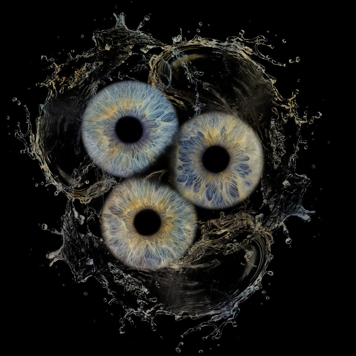 Three blue human irises arranged in a circular pattern with water splashes on black background create surreal artistic effect.