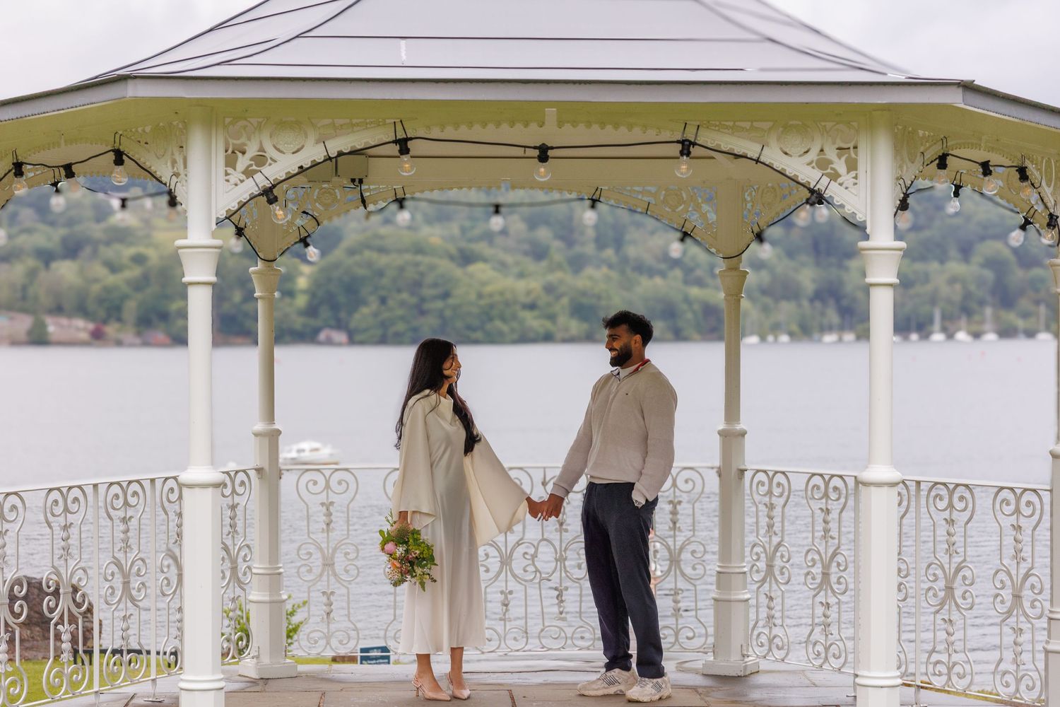 White gazebo overlooking water decorated for wedding ceremony.