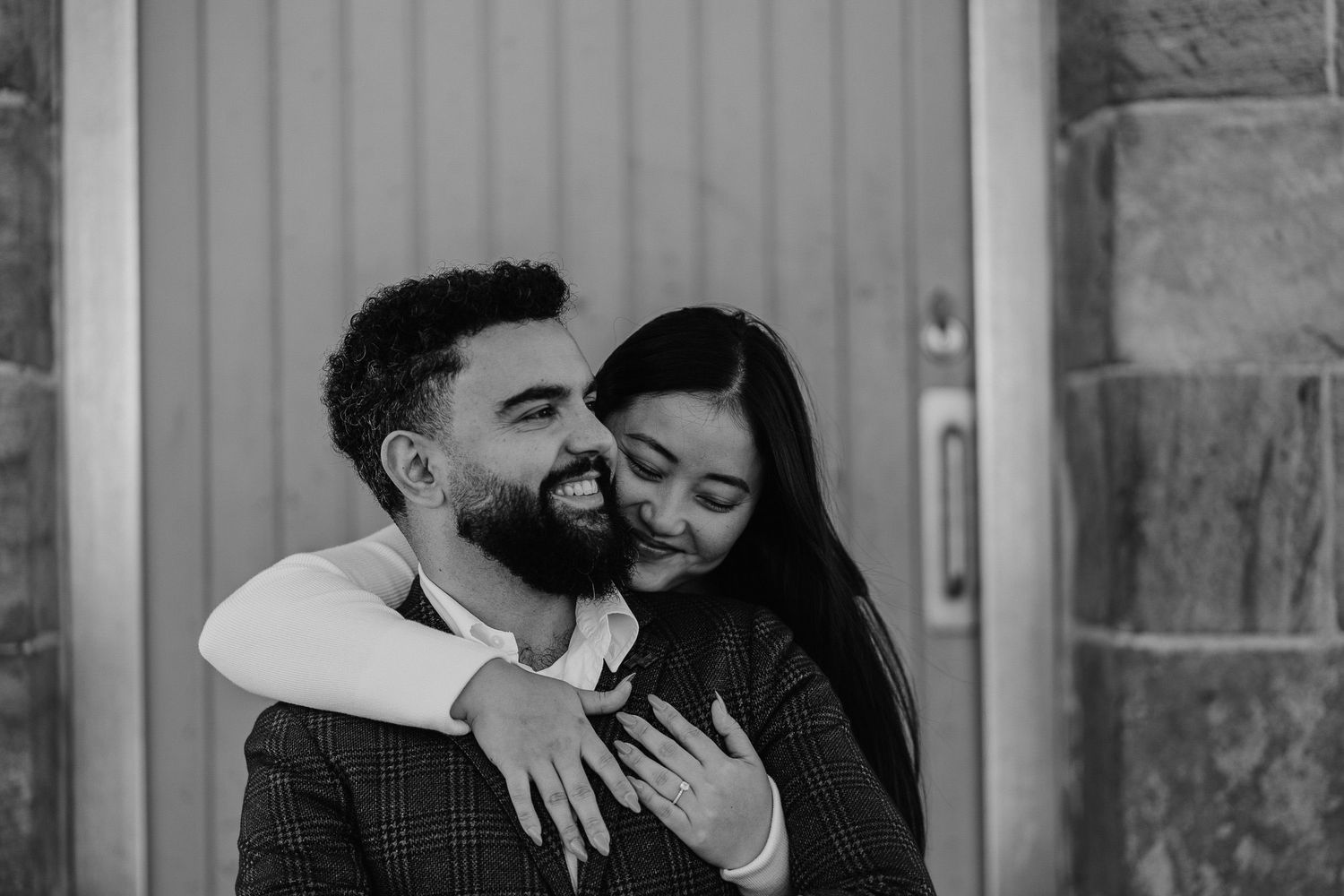 A romantic black and white portrait of a couple sharing a joyful moment together.