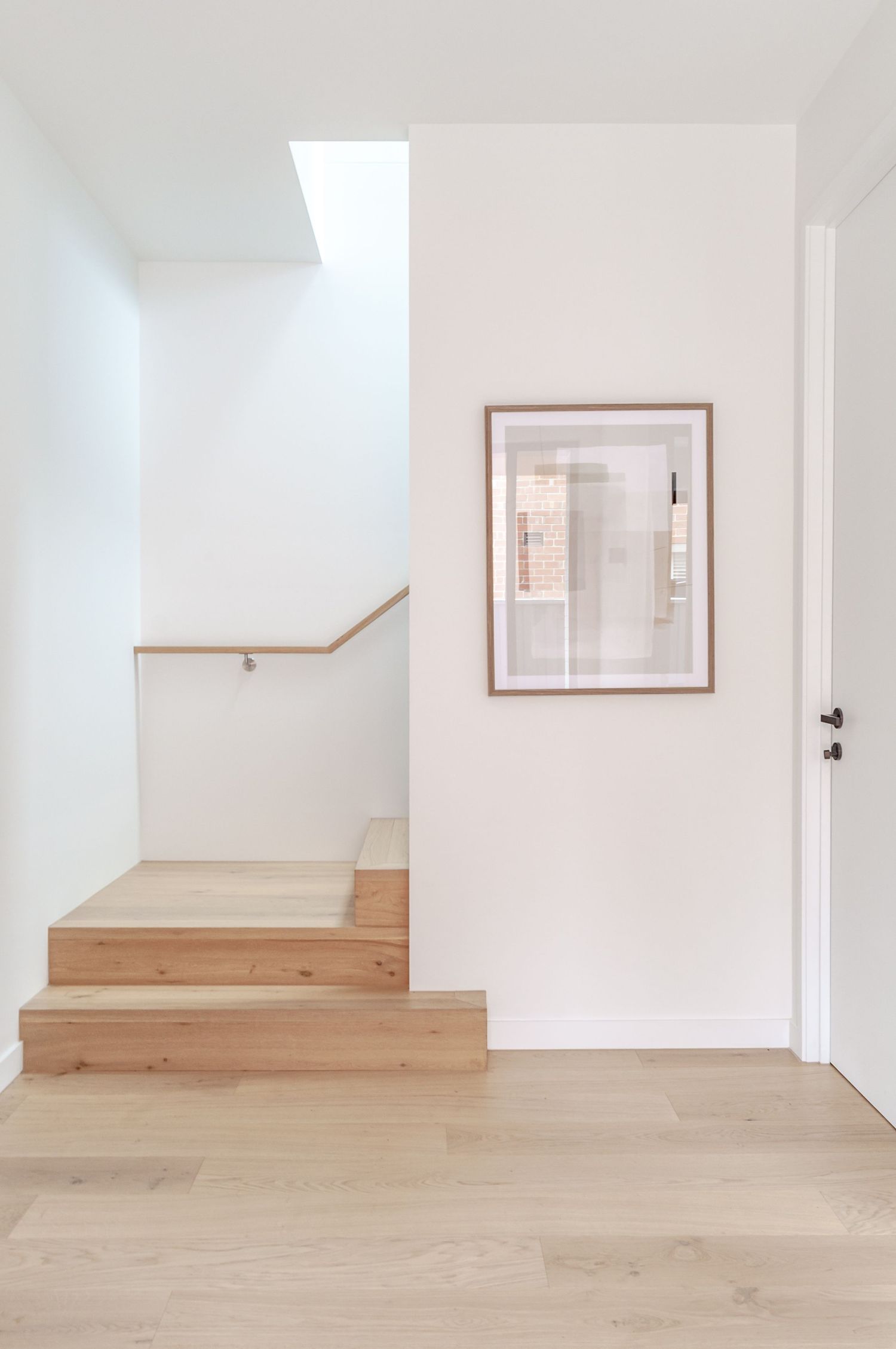 Bright interior space with light wooden flooring and white walls creates an airy, minimalist atmosphere.