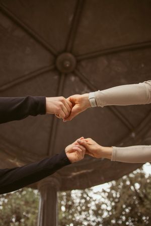 A series of close-up shots showing two people holding hands with intertwined fingers.