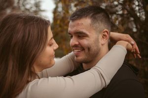 Intimate moment captured of couple embracing outdoors during autumn.