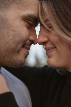 Close-up portrait of a romantic couple with their faces touching in an intimate moment.