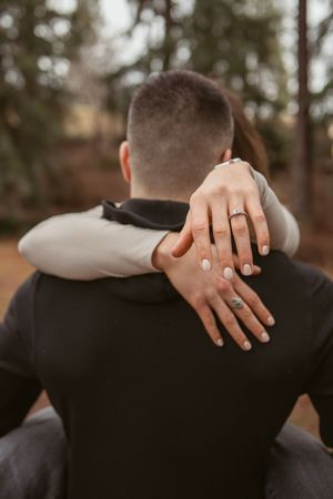 Series of close-up photos showing hands with an engagement ring embracing in soft, romantic lighting during a special moment.