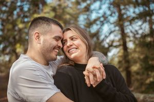 A joyful couple sharing a laugh while holding hands outdoors.