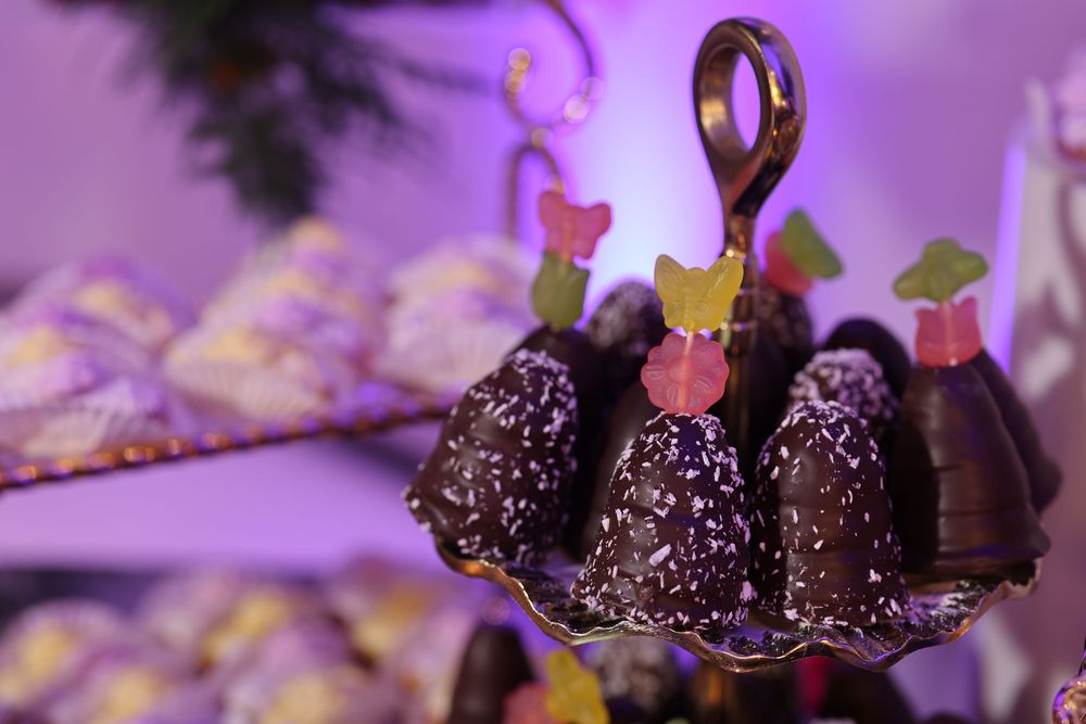 Elegant chocolate desserts topped with sparkly sugar crystals on a decorative serving platter.
