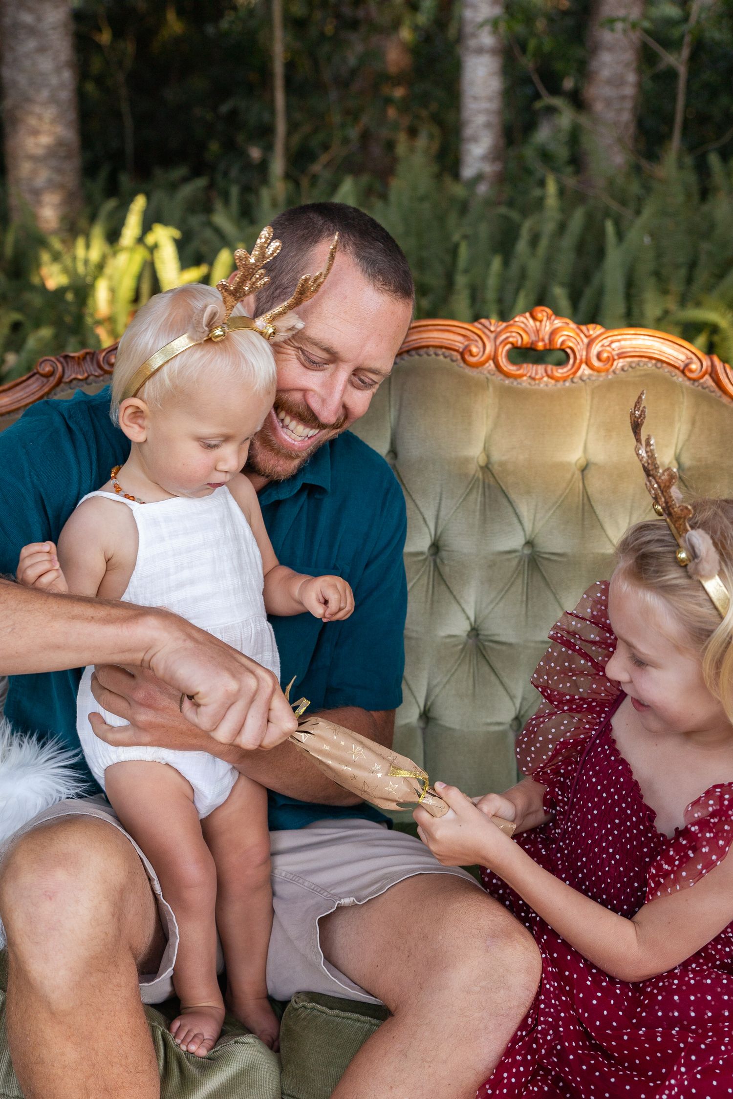 Heartwarming family moment captured on an elegant vintage sofa in an outdoor garden setting.