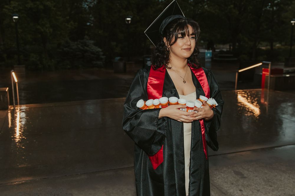 College senior at Eastern Washington University holding prescription bottles to celebrate mental health journey