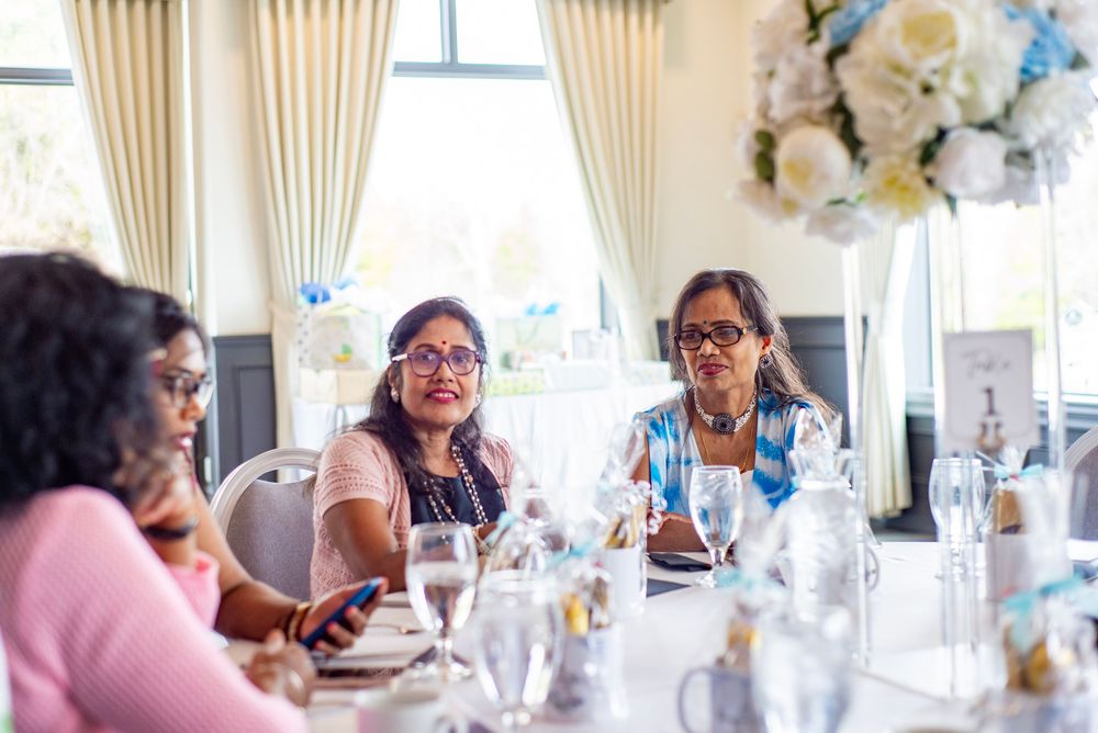 Guests having an animated conversation while seated at an elegant table setting during a social gathering.