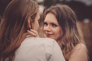 Artistic close-up portrait of two women sharing an intimate moment.