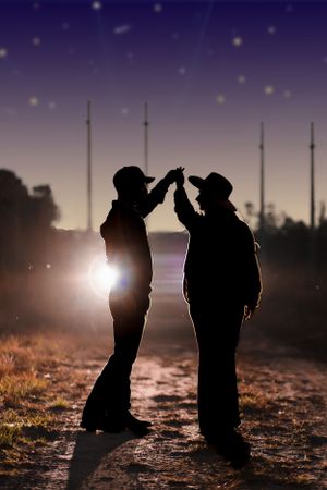 Two silhouettes share a high five against a starlit sky with transmission towers in the background.