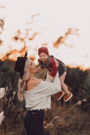 A touching moment between parent and child playing during golden hour in a field.