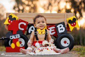 Mickey Mouse themed birthday celebration with smash cake and decorations.