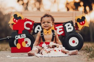 Baby celebrates with Mickey Mouse themed cake smash photoshoot.