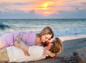 Intimate maternity photo of couple on beach at golden sunset.