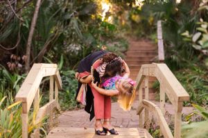 Romantic moment captured on a wooden garden bridge at sunset.
