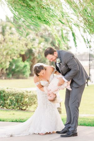 A romantic wedding moment captured outdoors under a weeping willow tree.