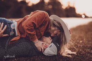 Intimate family moment captured during golden hour in a field.
