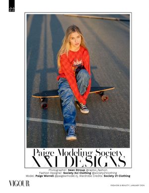 Casual skateboard fashion shot with model in red sweater and jeans sitting on board.