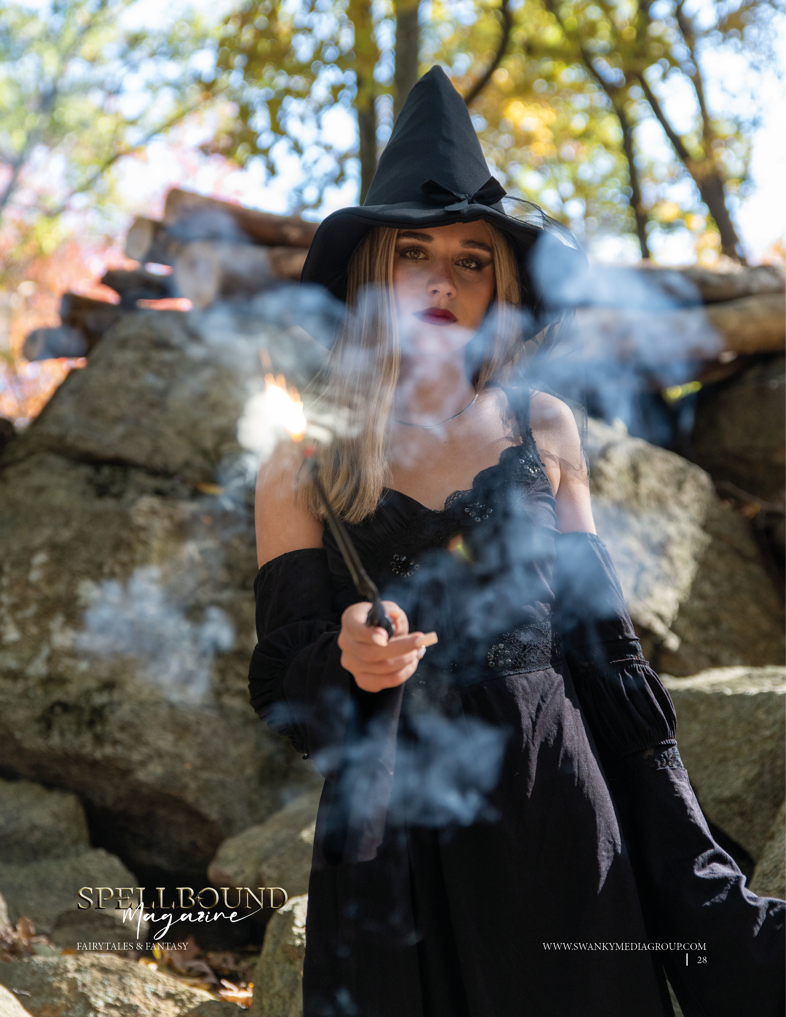 Artistic portrait of a witch in black clothing and hat with mystical smoke creating an ethereal atmosphere in nature.