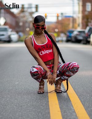 Urban fashion shoot with red-accented athletic wear and patterned pants on a city street.