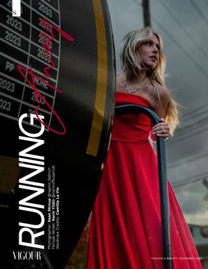 A dramatic fashion photo of someone in a red gown against an industrial background with numerical displays.
