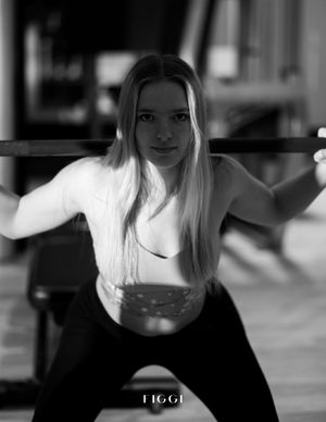 Black and white artistic portrait of someone in street style clothing posed in an expressive stance.
