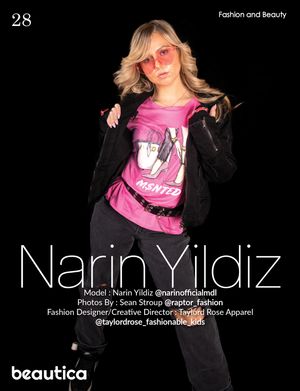 Model in pink graphic tee and black jacket poses against dark background with red sunglasses.