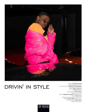 Fashion photo of someone posing on a car wearing a bright pink puffy jacket with orange accents in a dark setting.
