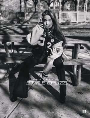 Black and white fashion photo featuring varsity jacket on outdoor bench.